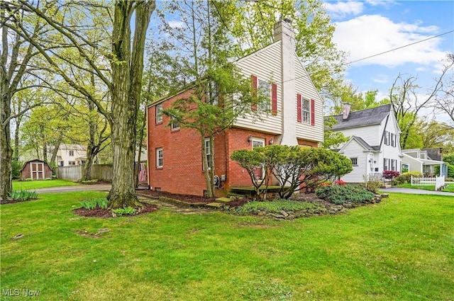 7219 N Lima Rd, Poland, OH 44514 - view of home's exterior featuring brick siding, a storage unit, and a chimney