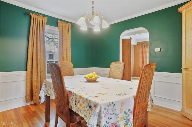 7219 N Lima Rd, Poland, OH 44514 - dining room with arched walkways, a chandelier, a wainscoted wall, light wood-style flooring, and ornamental molding