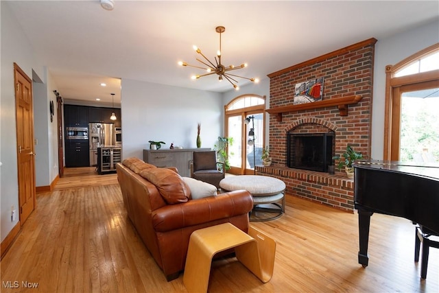 121 Sycamore Pl, Oberlin, OH 44074 - living area with light wood finished floors, healthy amount of natural light, a chandelier, and a fireplace