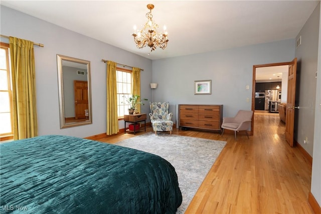 121 Sycamore Pl, Oberlin, OH 44074 - bedroom with stainless steel refrigerator with ice dispenser, a chandelier, and light wood-type flooring