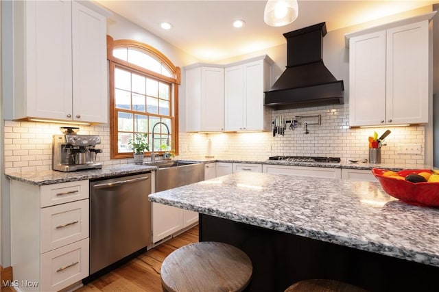 121 Sycamore Pl, Oberlin, OH 44074 - kitchen with stainless steel appliances, wall chimney exhaust hood, white cabinetry, light wood-style flooring, and backsplash