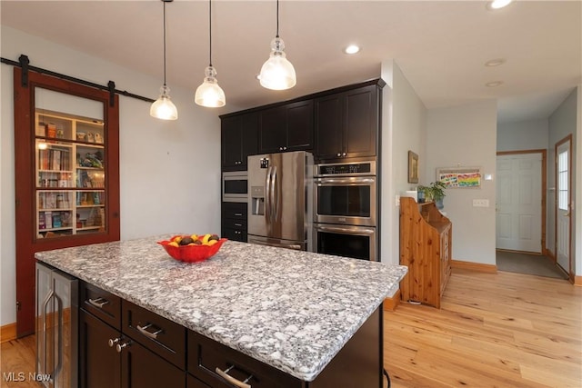 121 Sycamore Pl, Oberlin, OH 44074 - kitchen featuring appliances with stainless steel finishes, beverage cooler, light wood-style floors, a center island, and hanging light fixtures