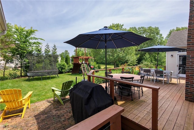 121 Sycamore Pl, Oberlin, OH 44074 - deck with outdoor dining area, a trampoline, a playground, a lawn, and area for grilling