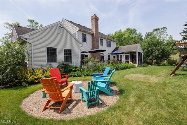 121 Sycamore Pl, Oberlin, OH 44074 - back of house featuring a sunroom, a lawn, and an outdoor fire pit