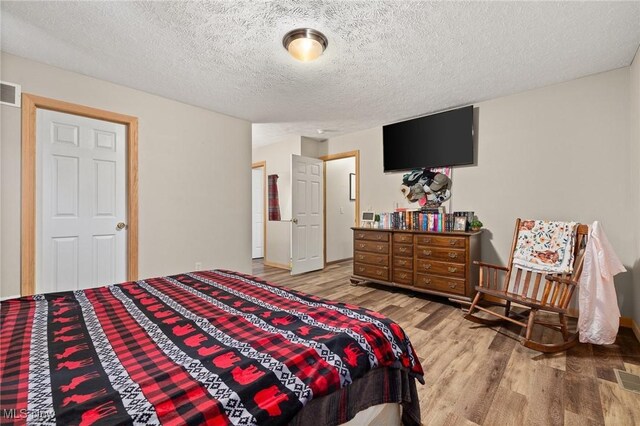 1345 County Road 16, New London, OH 44851 - bedroom with wood finished floors and a textured ceiling