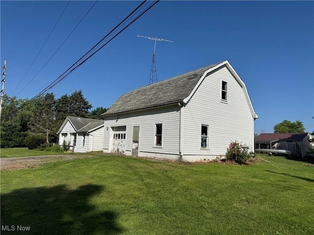 7138 Jefferson Rd, Ashtabula, OH 44004 - view of side of home with a yard, roof with shingles, a gambrel roof, and a garage