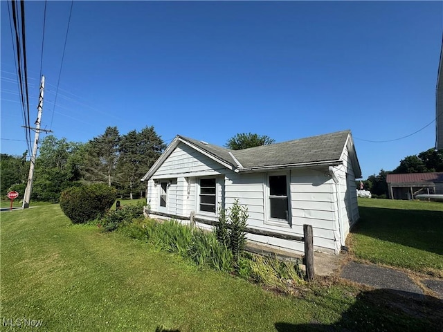7138 Jefferson Rd, Ashtabula, OH 44004 - view of side of property with a lawn and a shingled roof