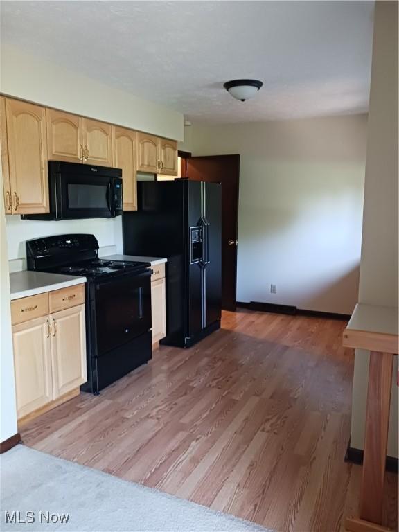 14172 Hametown Rd, Doylestown, OH 44230 - kitchen with black appliances, light wood-type flooring, light brown cabinets, and light countertops