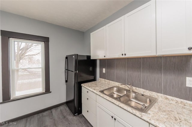 1431 Rowley Ave, Cleveland, OH 44109 - kitchen featuring freestanding refrigerator, light countertops, wood finished floors, and white cabinets