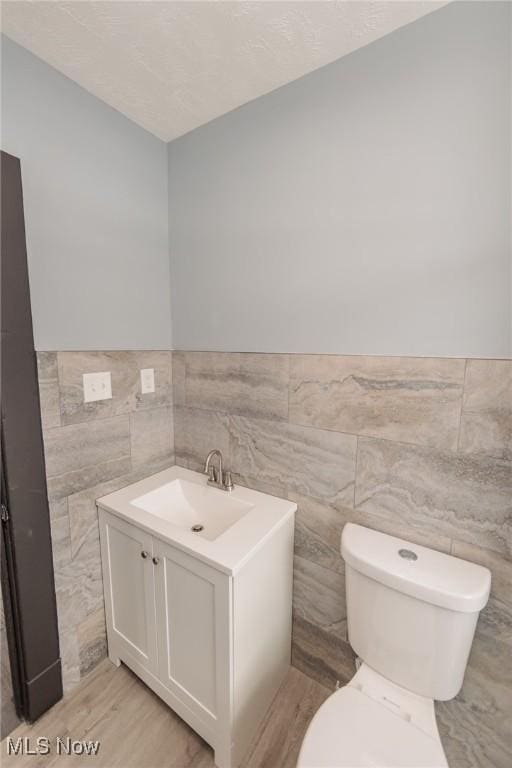 1431 Rowley Ave, Cleveland, OH 44109 - half bath featuring tile walls, vanity, wood finished floors, and wainscoting