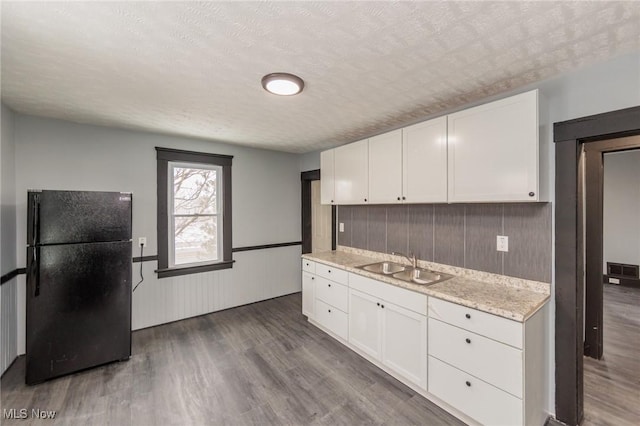 1431 Rowley Ave, Cleveland, OH 44109 - kitchen with freestanding refrigerator, wood finished floors, white cabinets, a textured ceiling, and light stone countertops