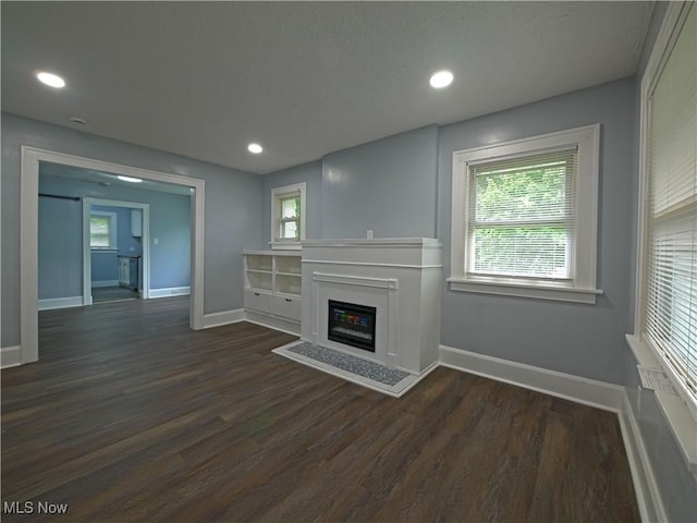 1033 Chalker St, Akron, OH 44310 - unfurnished living room featuring dark wood-style flooring, a glass covered fireplace, and recessed lighting