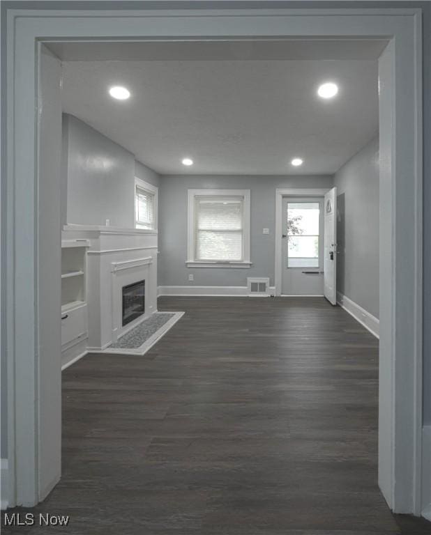 1033 Chalker St, Akron, OH 44310 - unfurnished living room with dark wood-style flooring, a fireplace with flush hearth, and recessed lighting