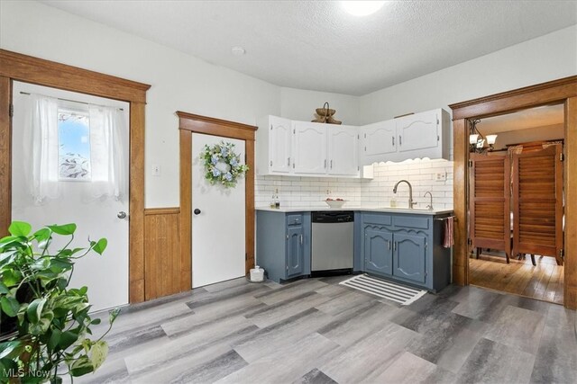 201 E Spring St, Marietta, OH 45750 - kitchen with dishwasher, white cabinetry, light wood finished floors, light countertops, and a wainscoted wall