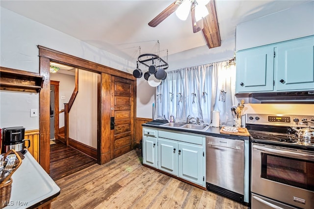 1833 W 7th St, Ashtabula, OH 44004 - kitchen featuring stainless steel appliances, under cabinet range hood, a ceiling fan, light wood finished floors, and a wainscoted wall