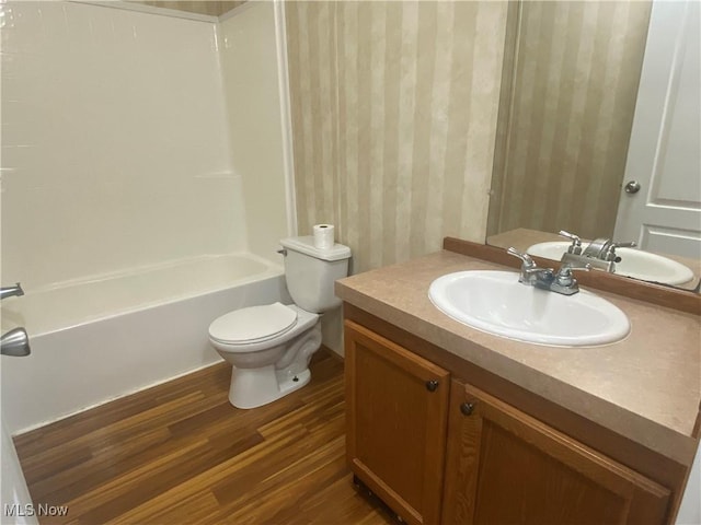 67330 Ebbert Rd Unit 9, Saint Clairsville, OH 43950 - bathroom featuring wallpapered walls, wood finished floors, vanity, and bathtub / shower combination