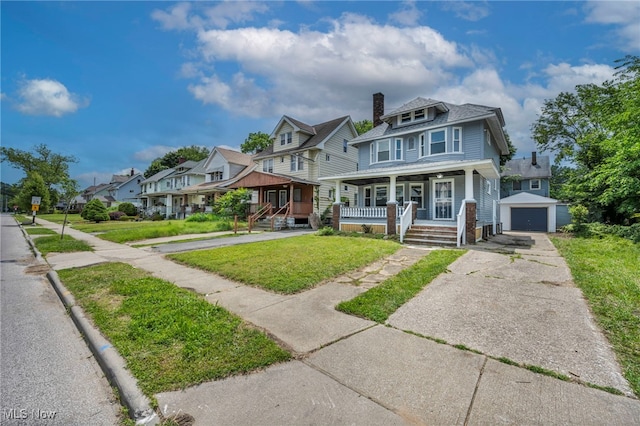 12616 Arlington Ave, Cleveland, OH 44108 - view of front of property with a porch, asphalt driveway, a detached garage, a residential view, and a front lawn