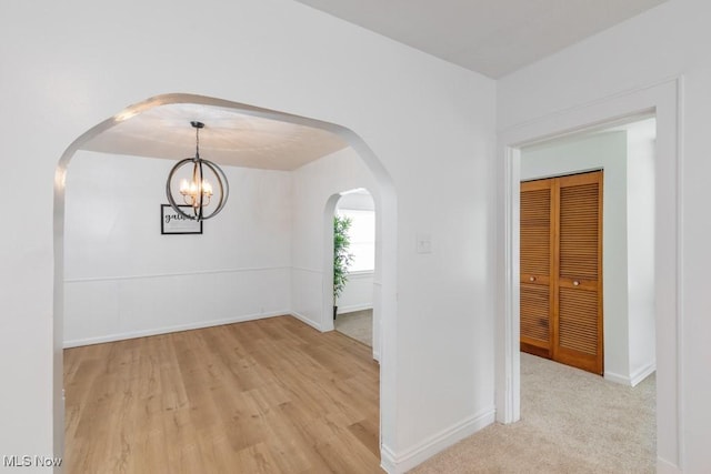 2830 Harmont Ave NE, Canton, OH 44705 - spare room featuring arched walkways, light wood-style floors, and a chandelier