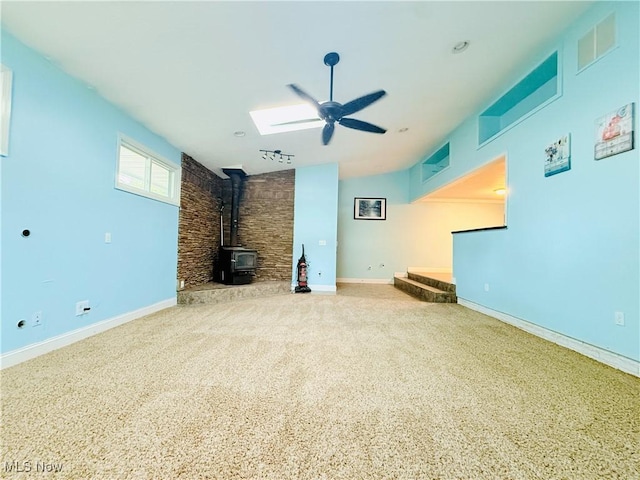 133 Walleye Ct, Lagrange, OH 44050 - unfurnished living room with a wood stove, ceiling fan, vaulted ceiling, and carpet flooring