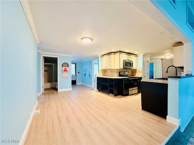 133 Walleye Ct, Lagrange, OH 44050 - kitchen with appliances with stainless steel finishes, crown molding, decorative backsplash, light wood finished floors, and dark cabinets