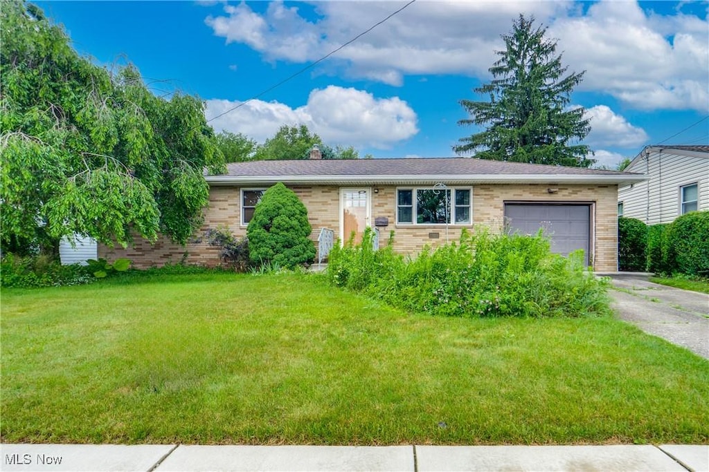 73 Sunrise Blvd E, Mogadore, OH 44260 - single story home with a garage, driveway, a front yard, and a chimney