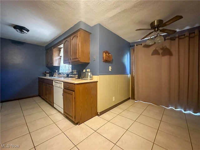 1422 Youll St, Niles, OH 44446 - kitchen with white dishwasher, light countertops, ceiling fan, light tile patterned floors, and wainscoting