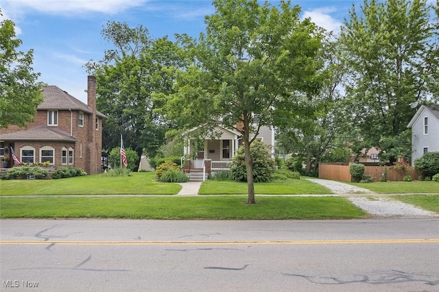 436 N Portage St, Doylestown, OH 44230 - obstructed view of property featuring a porch, driveway, brick siding, and a chimney
