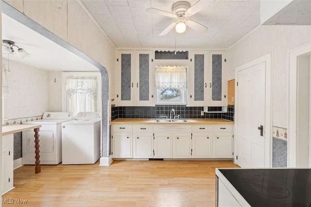 436 N Portage St, Doylestown, OH 44230 - kitchen with independent washer and dryer, ceiling fan, white cabinetry, light wood-style flooring, and tasteful backsplash