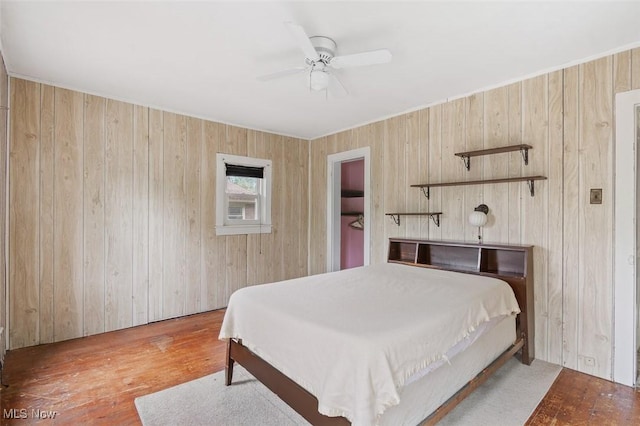 436 N Portage St, Doylestown, OH 44230 - bedroom with wood finished floors, wooden walls, and a ceiling fan