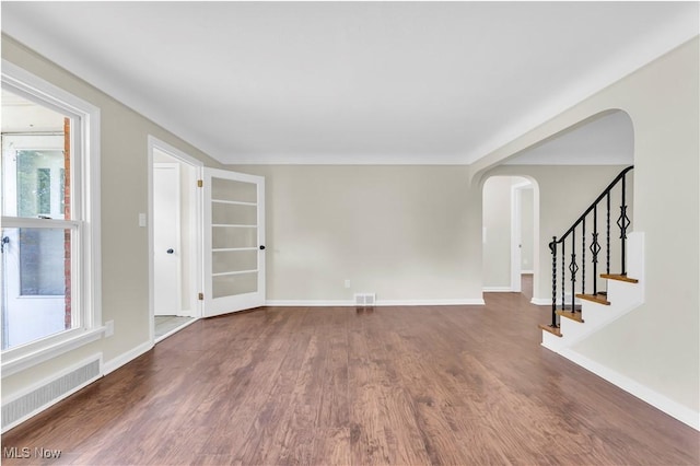 416 E 255th St, Euclid, OH 44132 - unfurnished room featuring arched walkways, wood finished floors, plenty of natural light, and stairway