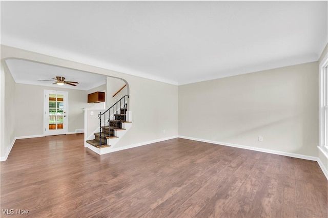 416 E 255th St, Euclid, OH 44132 - spare room featuring stairs, dark wood-type flooring, ceiling fan, and arched walkways