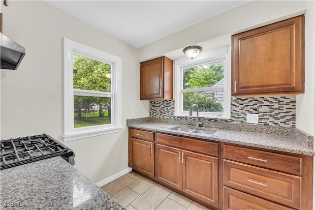 416 E 255th St, Euclid, OH 44132 - kitchen featuring backsplash, healthy amount of natural light, gas stove, and brown cabinets