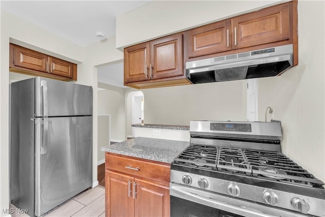 416 E 255th St, Euclid, OH 44132 - kitchen with stainless steel appliances, under cabinet range hood, brown cabinets, and arched walkways