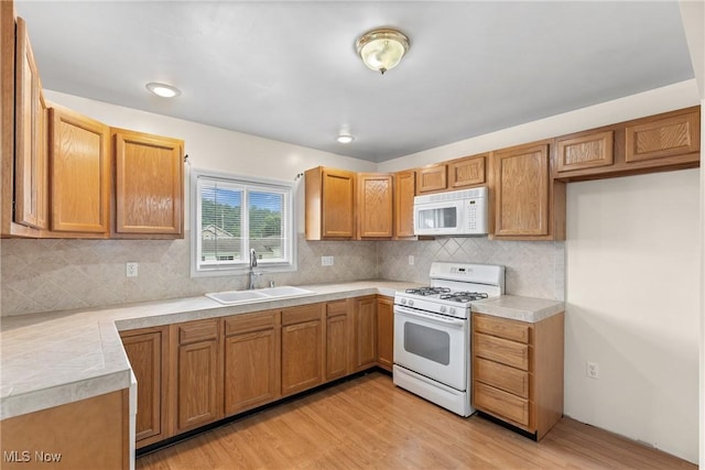 3480 Central Ave, Shadyside, OH 43947 - kitchen featuring white appliances, light countertops, light wood-type flooring, backsplash, and brown cabinetry