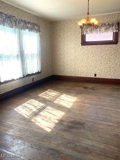 104 Jefferson St, Belmont, OH 43718 - unfurnished room with dark wood-style flooring, plenty of natural light, a chandelier, and wallpapered walls