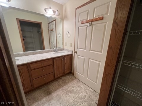 2132 University Commons Dr SE, Massillon, OH 44646 - full bath with double vanity, a walk in closet, and tile patterned flooring