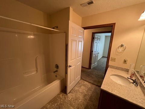 2132 University Commons Dr SE, Massillon, OH 44646 - bathroom featuring vanity, bathing tub / shower combination, and a textured ceiling