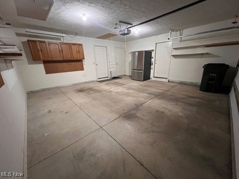 2132 University Commons Dr SE, Massillon, OH 44646 - garage with freestanding refrigerator and a garage door opener