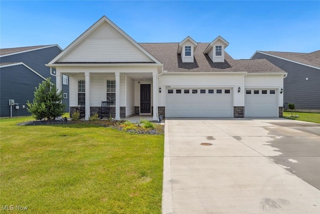 23761 St Andrews Dr, Columbia Station, OH 44028 - view of front of property featuring a garage, stone siding, a front yard, driveway, and covered porch