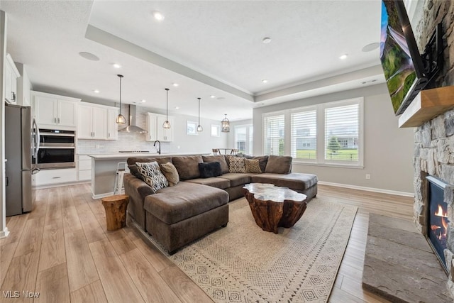 23761 St Andrews Dr, Columbia Station, OH 44028 - living area with light wood-style floors, a raised ceiling, a fireplace, and recessed lighting
