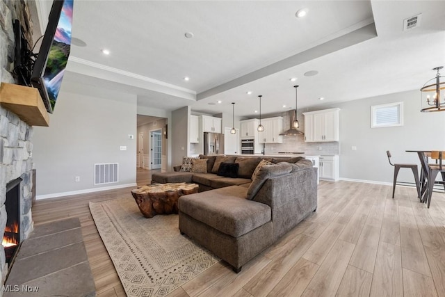 23761 St Andrews Dr, Columbia Station, OH 44028 - living room with a raised ceiling, light wood finished floors, a fireplace, ornamental molding, and recessed lighting