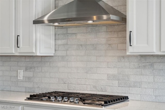 23761 St Andrews Dr, Columbia Station, OH 44028 - kitchen with wall chimney range hood, stainless steel gas cooktop, white cabinets, and decorative backsplash