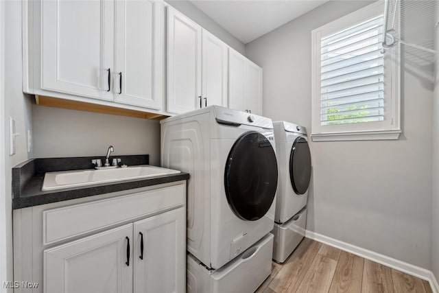 23761 St Andrews Dr, Columbia Station, OH 44028 - washroom featuring washing machine and clothes dryer, cabinet space, and light wood-style floors