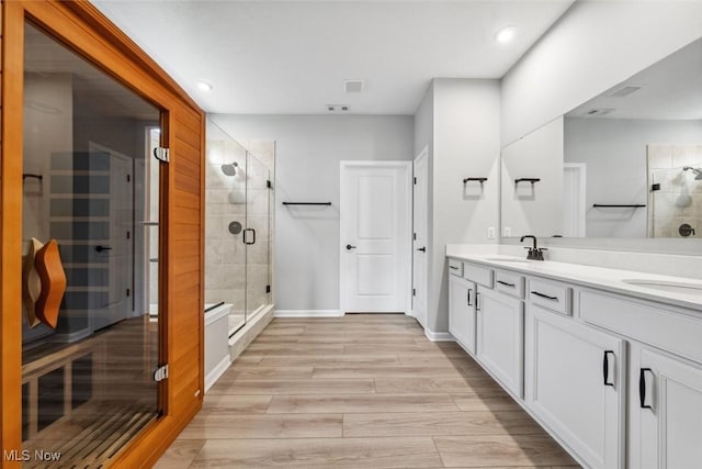 23761 St Andrews Dr, Columbia Station, OH 44028 - full bathroom featuring double vanity, wood finished floors, a stall shower, and recessed lighting