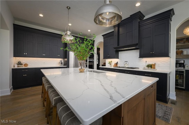 7324 Roman Ave NW, Massillon, OH 44646 - kitchen with arched walkways, wood finished floors, stainless steel gas stovetop, and recessed lighting