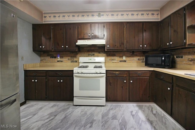 8630 Williams Rd, Chardon, OH 44024 - kitchen featuring gas range gas stove, black microwave, under cabinet range hood, freestanding refrigerator, and light countertops