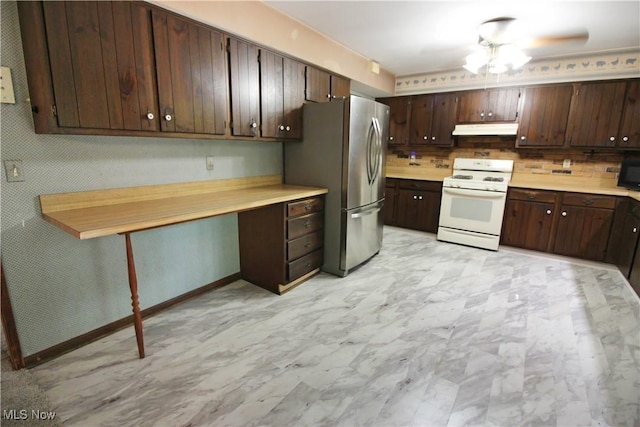 8630 Williams Rd, Chardon, OH 44024 - kitchen featuring white range with gas stovetop, under cabinet range hood, freestanding refrigerator, built in desk, and light countertops