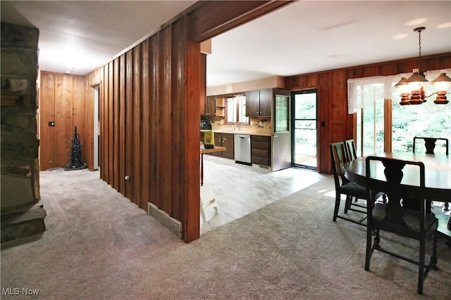 8630 Williams Rd, Chardon, OH 44024 - dining space with wooden walls, a chandelier, and light carpet
