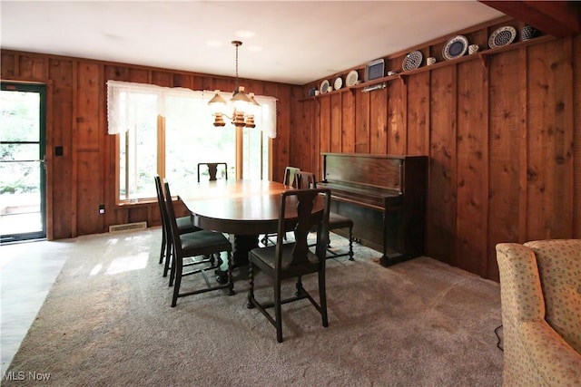 8630 Williams Rd, Chardon, OH 44024 - dining room featuring a chandelier, wood walls, and carpet