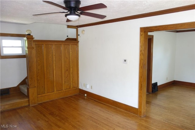 1825 Glenmount Ave, Akron, OH 44301 - empty room with light wood finished floors, a ceiling fan, a textured ceiling, and crown molding